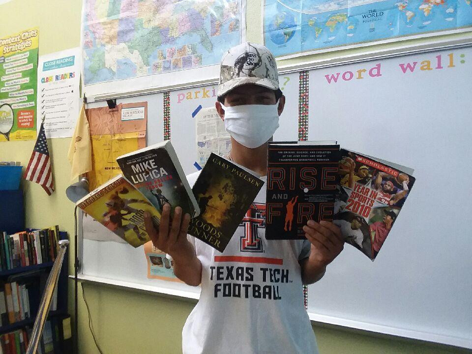 Students in masks choosing books for remote learning
